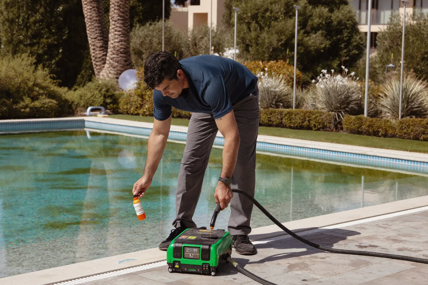 Technician using electronic leak detection equipment at a pool edge
